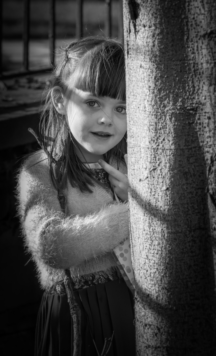 Jo Newbury Photography portrait portrait of child peeking from behind tree