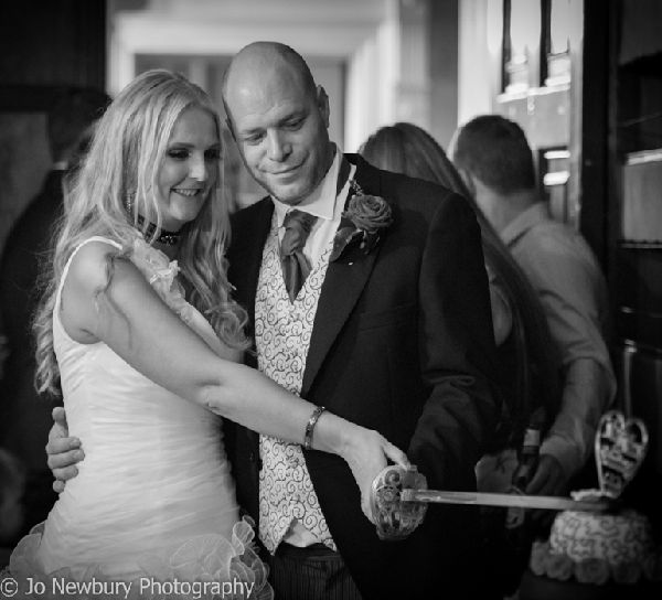 Jo Newbury Photography wedding image bride and groom cutting cake.